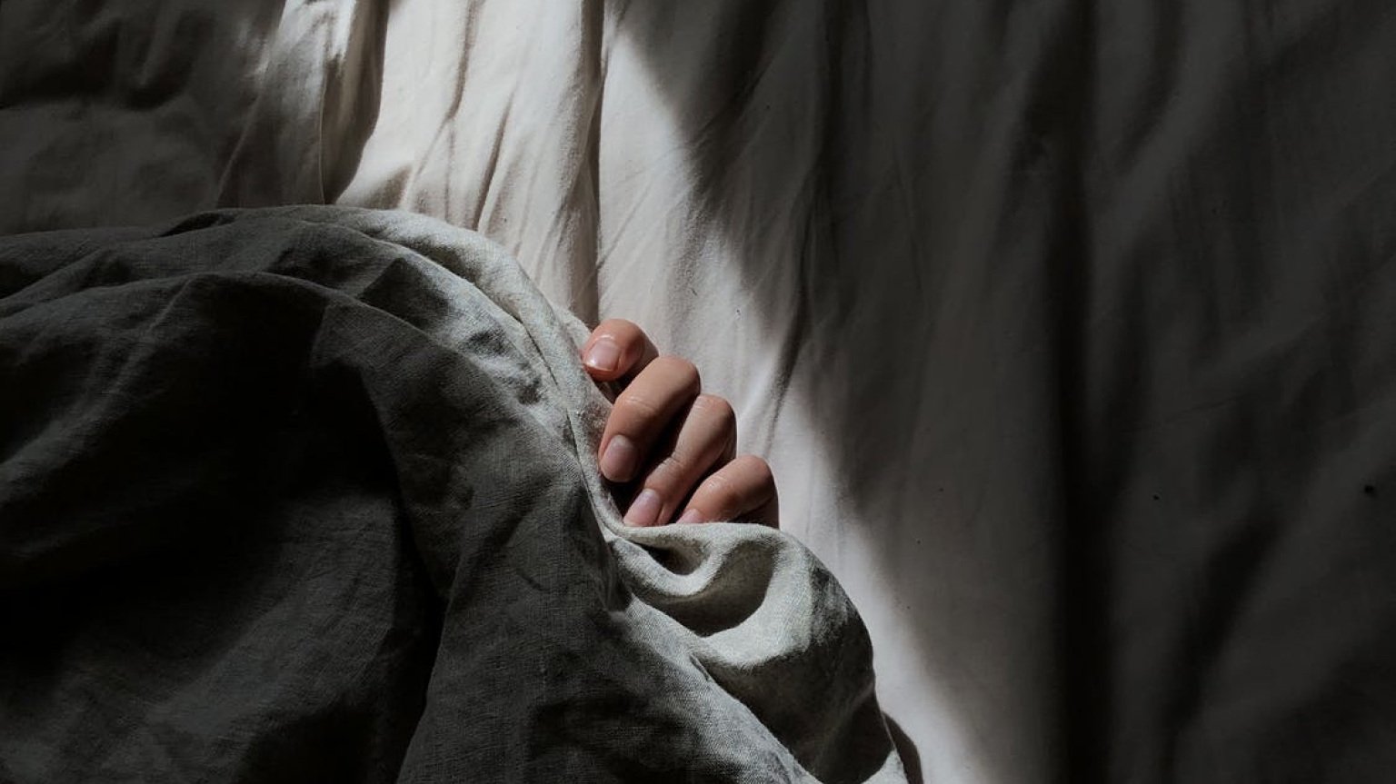 a person gripping on to bedsheets