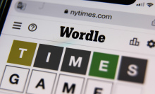 A photo of a smartphone showing a 'Wordle' game in progress.