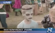 A kid with zombie face paint is interviewed by a local news reporter.