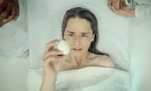 Emilia Clarke holds an egg in "Pod Generation."