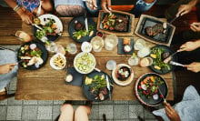 Bird's eye view of people gathered around a table full of food.