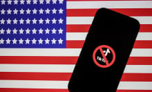 Logo of Tiktok is displayed on mobile phone screen in front of flag of United States, in Ankara, Turkiye on April 20, 2023.