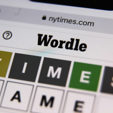 A photo of a smartphone showing a 'Wordle' game in progress.