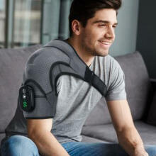 man on couch with shoulder massager on