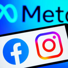 Facebook and Instagram logos on a smartphone in front of the Meta logo
