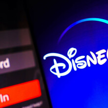 The Disney Plus logo is displayed on a smartphone screen, next to a login screen, with email, password and sign in.
