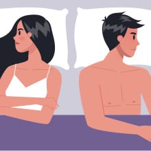 A man and woman lying in bed facing opposite directions.