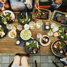 Bird's eye view of people gathered around a table full of food.