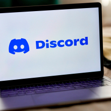 The Discord logo is visible on a laptop screen.