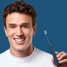 man smiling and holding toothbrush