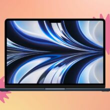 macbook pro on yellow-orange background with pink stickers