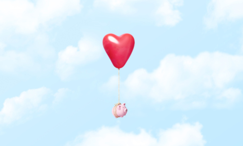 Piggy bank tied to a red heart ballon in clouds