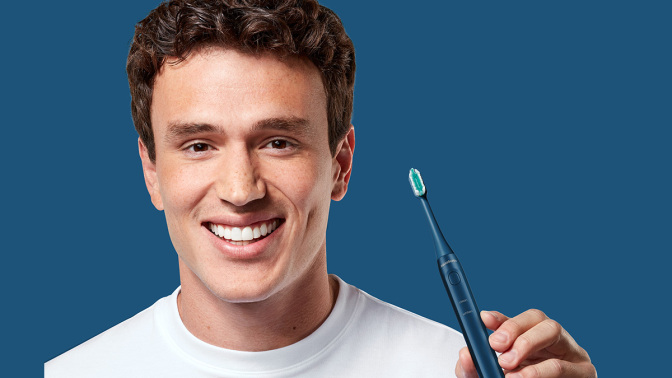 man smiling and holding toothbrush