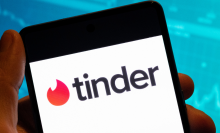 The tinder logo on a white mobile phone screen.