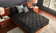 a top-down view of a black Beautyrest mattress on a bed next to two wooden side tables