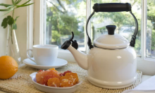 white Le Creuset tea kettle next to oranges