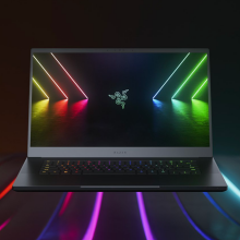 a razer blade 15 gaming laptop sitting on a surface embedded with colorful striped lights against a black background