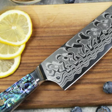 Ryori chef knife laying on counter with lemons, onions, and other fruits