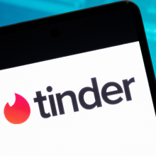 The tinder logo on a white mobile phone screen.