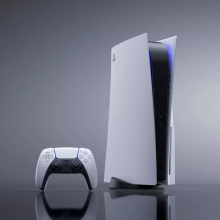 the playstation 5 and a dualsense wireless controller on top of a gray reflective surface