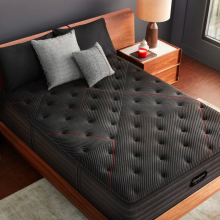 a top-down view of a black Beautyrest mattress on a bed next to two wooden side tables